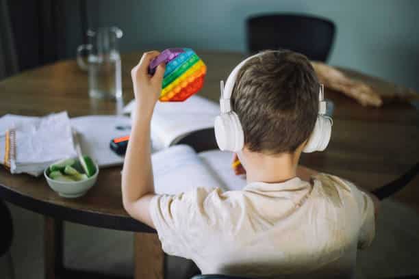 autism testing in new york a child studies with headphones and a pop-it toy