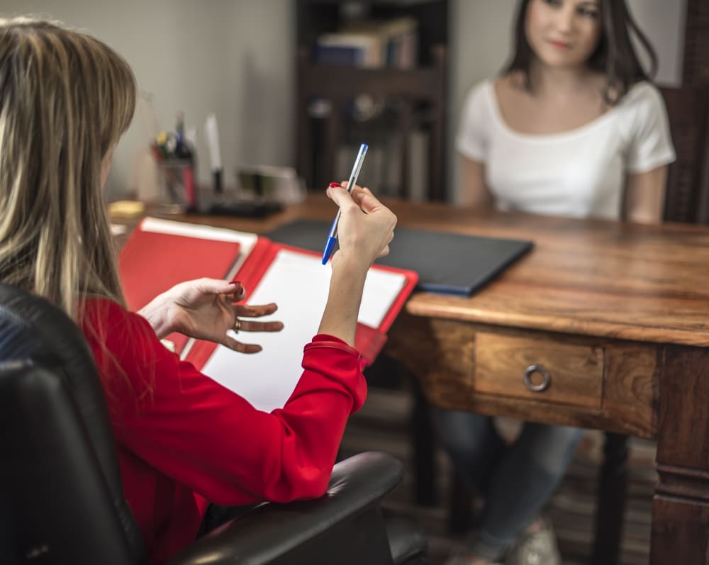 forensics new york a professional talks with a client across a desk during a consultation